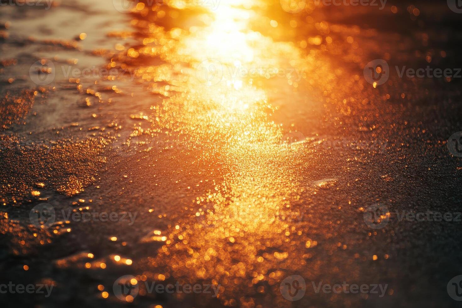 Sunset glow reflecting on wet sandy surface near the shoreline during a calm evening photo