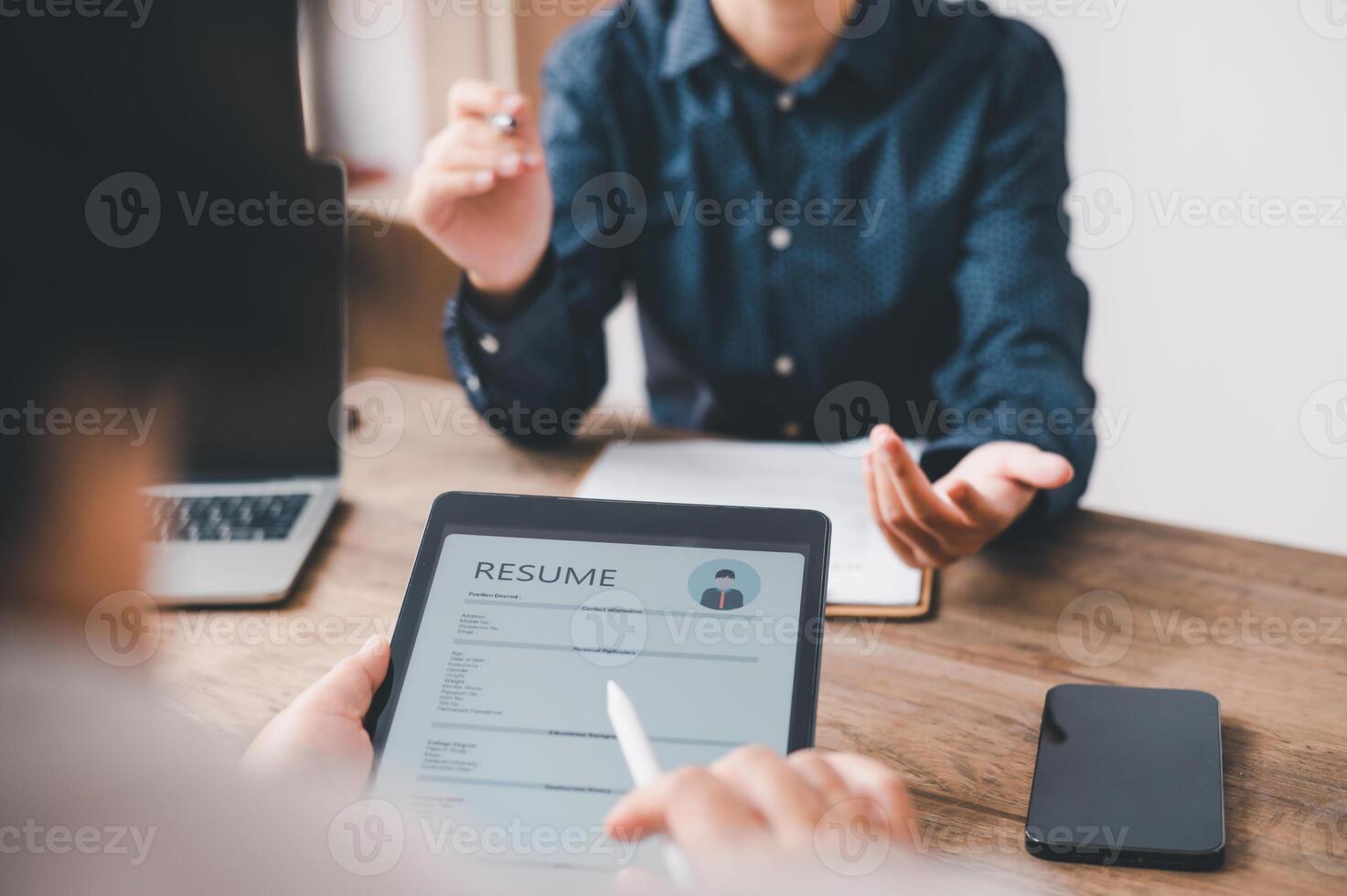 HR managers are interviewing job applicants who fill out their resume on the job application form in order to consider accepting a job as a company photo