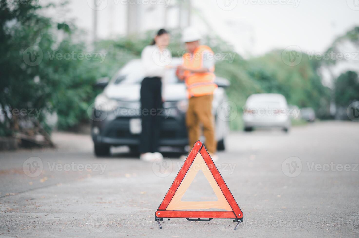 red emergency triangle on the road indicates that there is an accident or car breakdown on the road ahead. photo