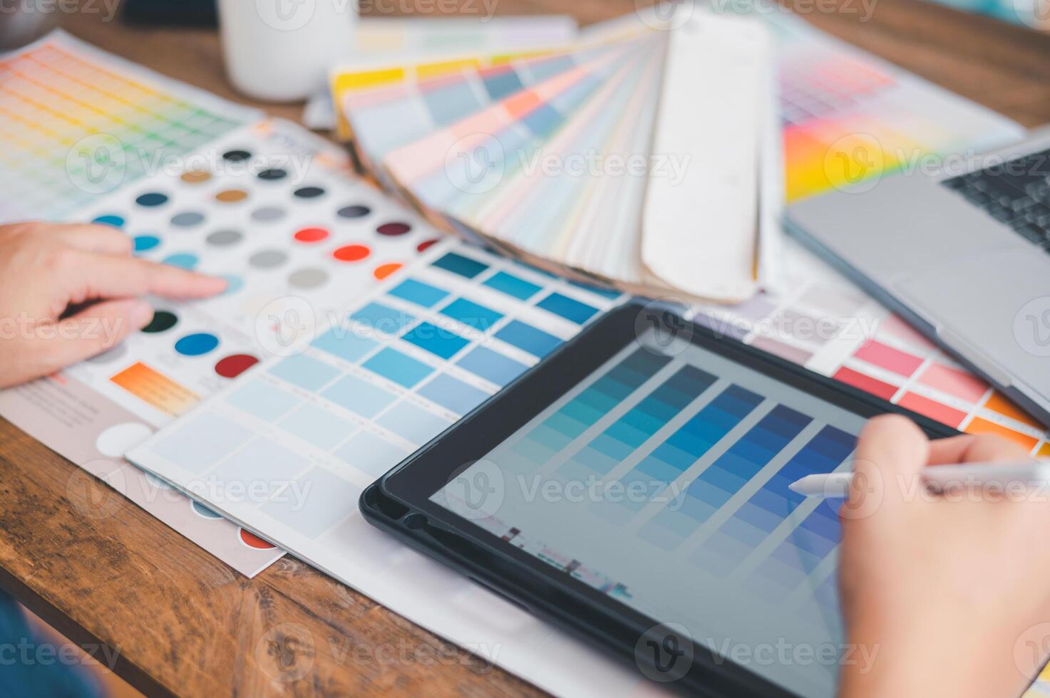 Graphic designer architects who work with laptops and color comparison tables for design work. photo