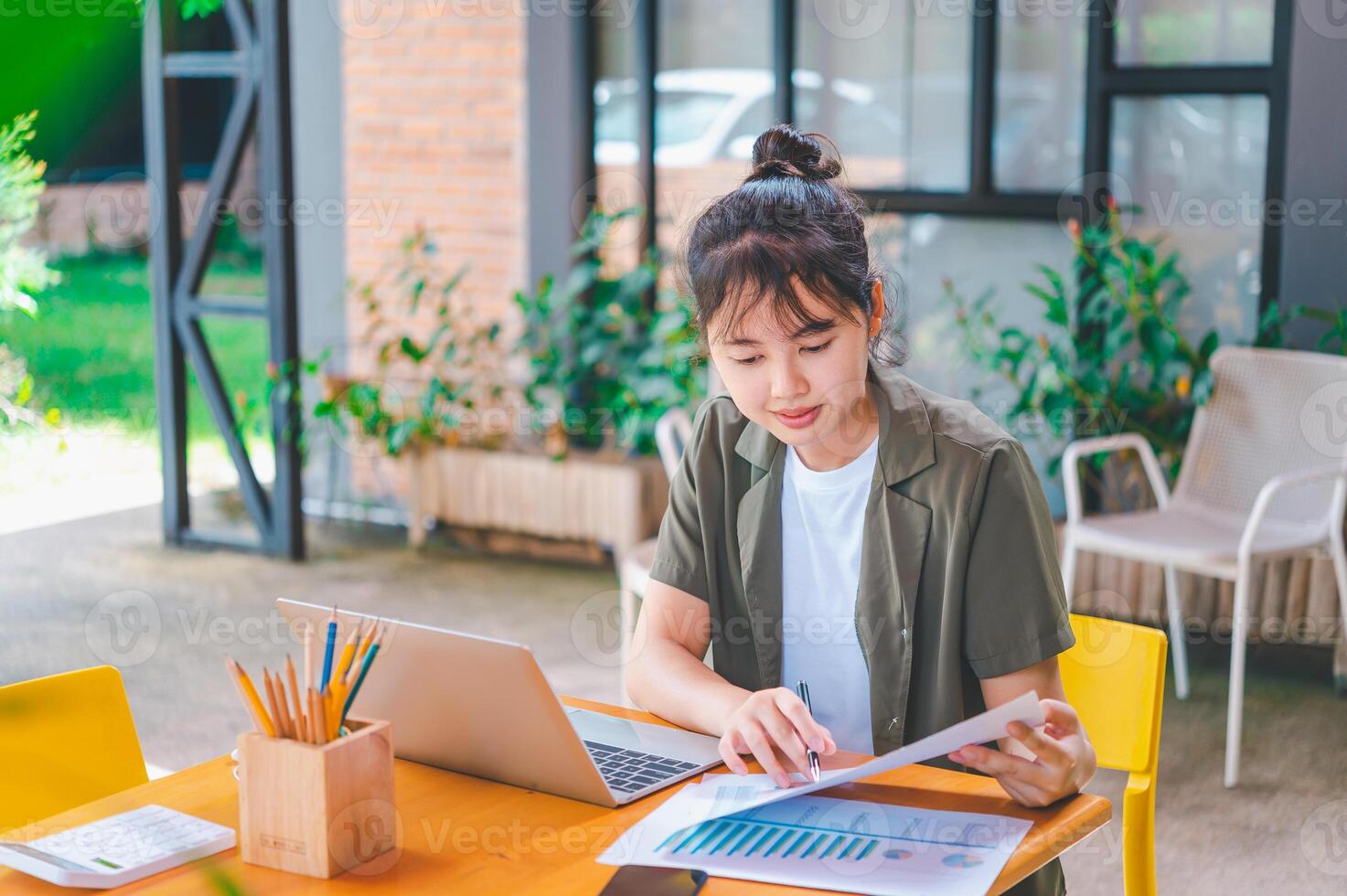Freelance worker working on documents with graphs. and information about finances on laptops in cafes photo