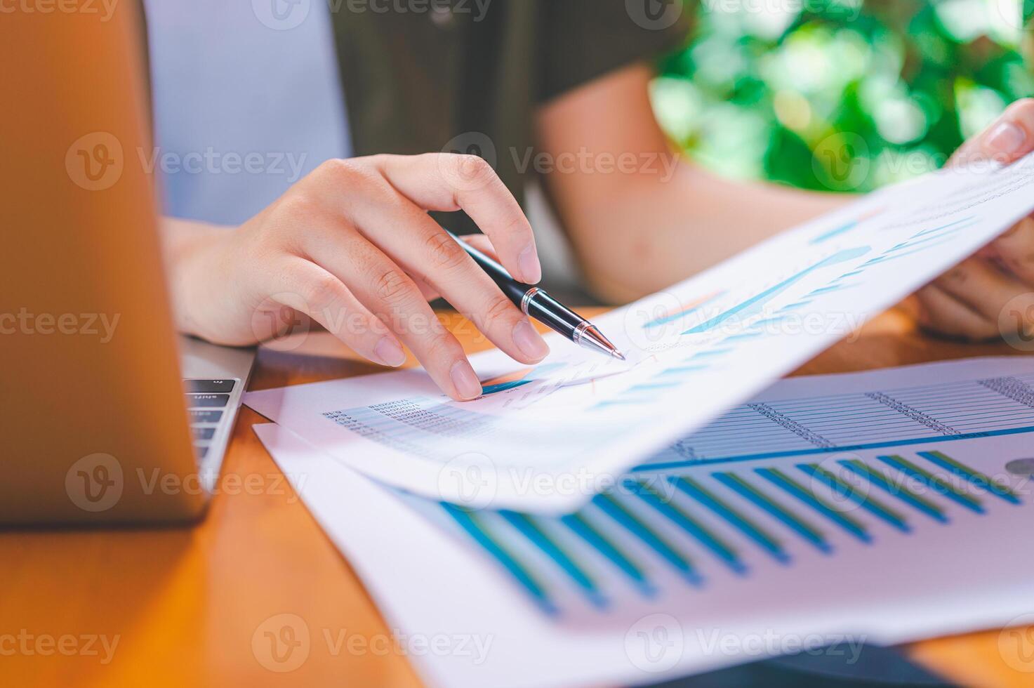 Freelance worker working on documents with graphs. and information about finances on laptops in cafes photo