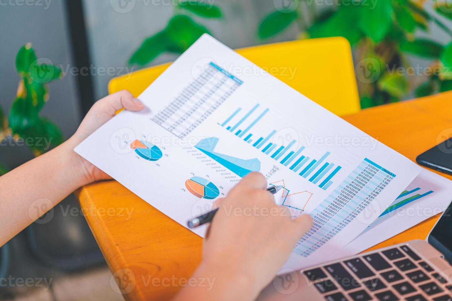Freelance worker working on documents with graphs. and information about finances on laptops in cafes photo
