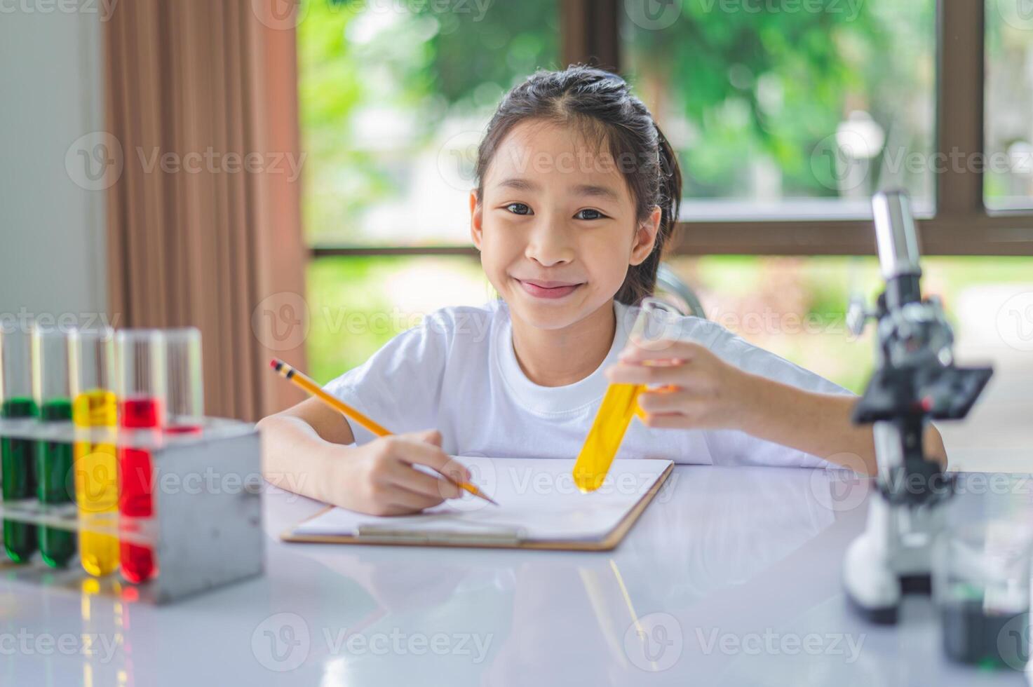 little scientist looking through a microscope and test tubes filled with chemicals for learning about science and experiments. photo