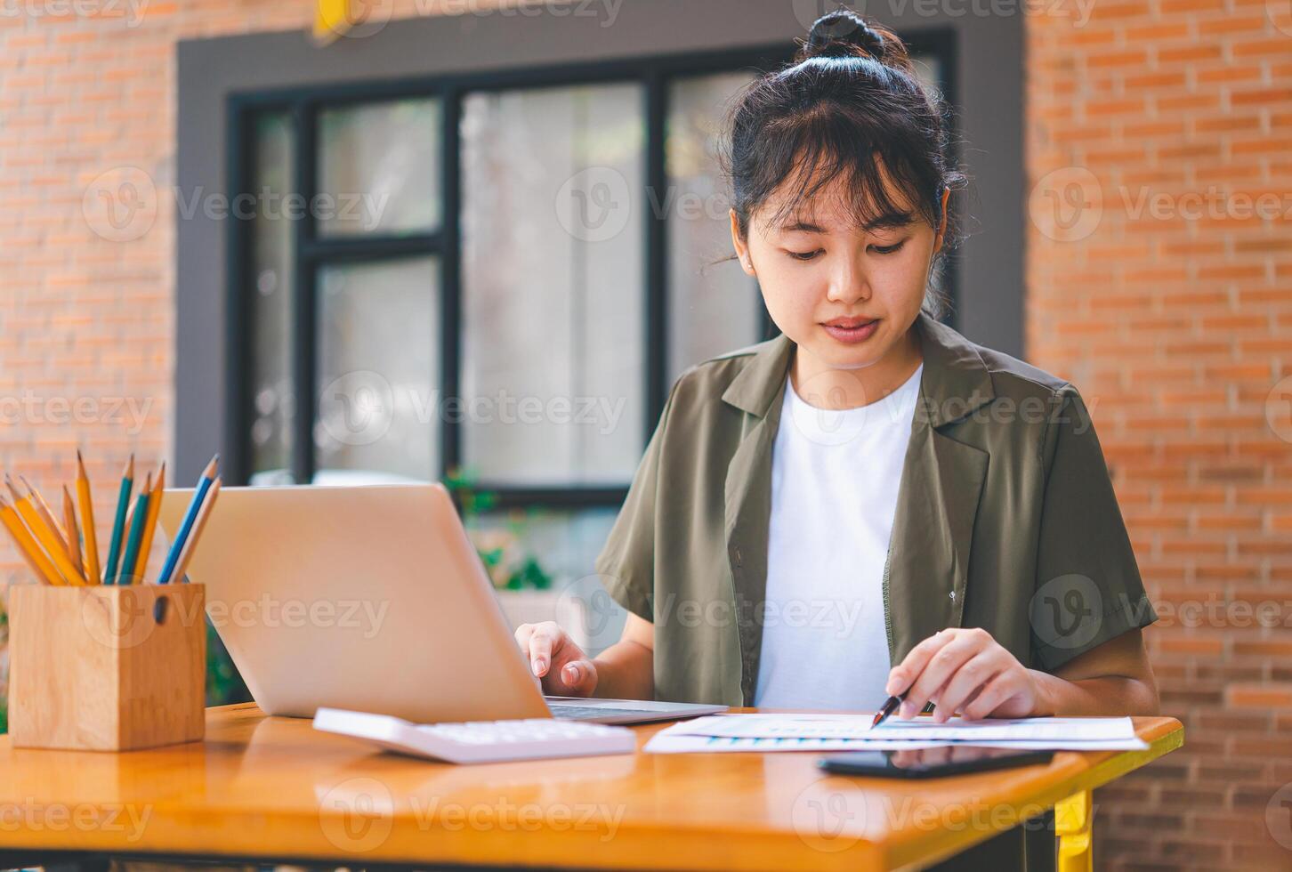 Freelance worker working on documents with graphs. and information about finances on laptops in cafes photo