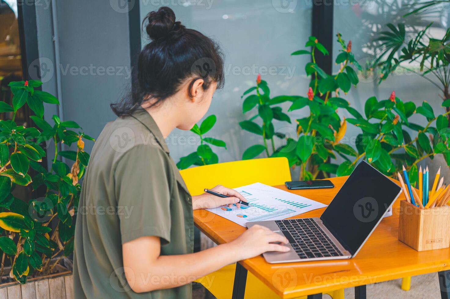 Freelance worker working on documents with graphs. and information about finances on laptops in cafes photo