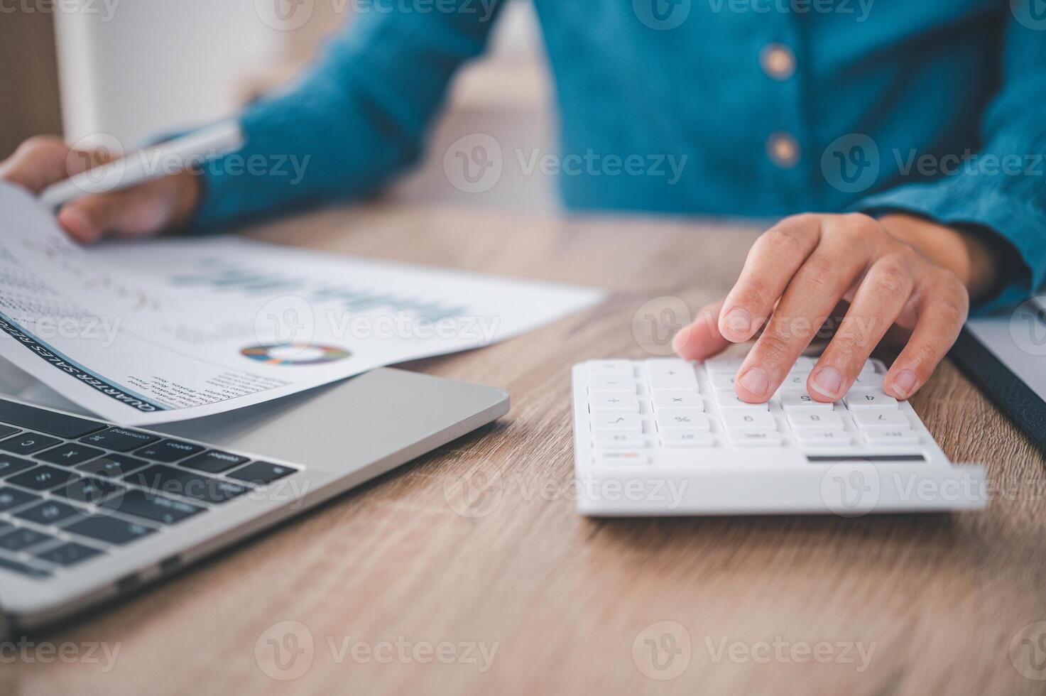 close up The business person is sitting on a calculator with a graph in the office of finance accounting concept photo