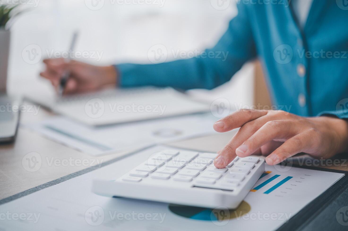 close up The business person is sitting on a calculator with a graph in the office of finance accounting concept photo
