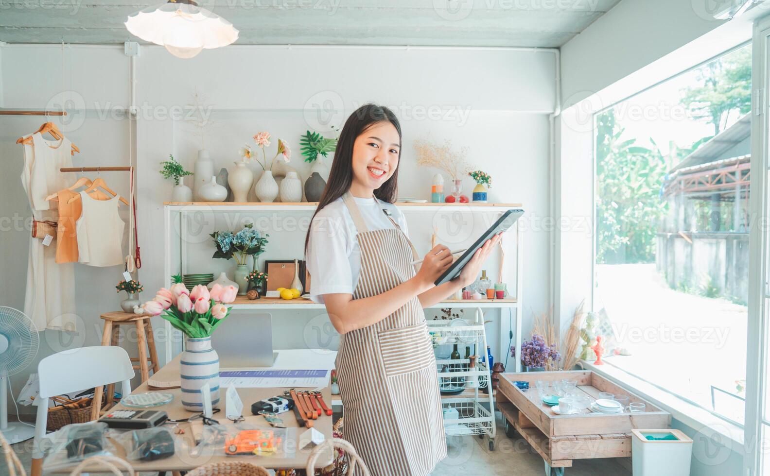 Small business owners are preparing a small shop and checking through a tablet and checking orders. photo