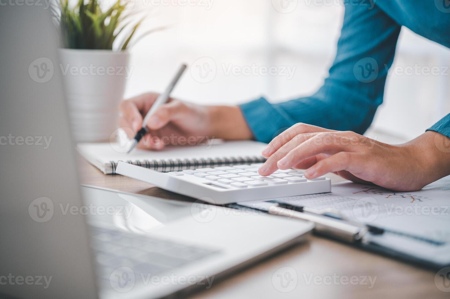 close up The business person is sitting on a calculator with a graph in the office of finance accounting concept photo