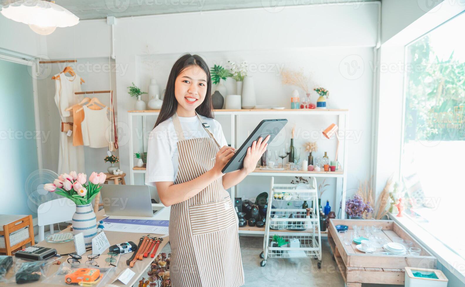Small business owners are preparing a small shop and checking through a tablet and checking orders. photo