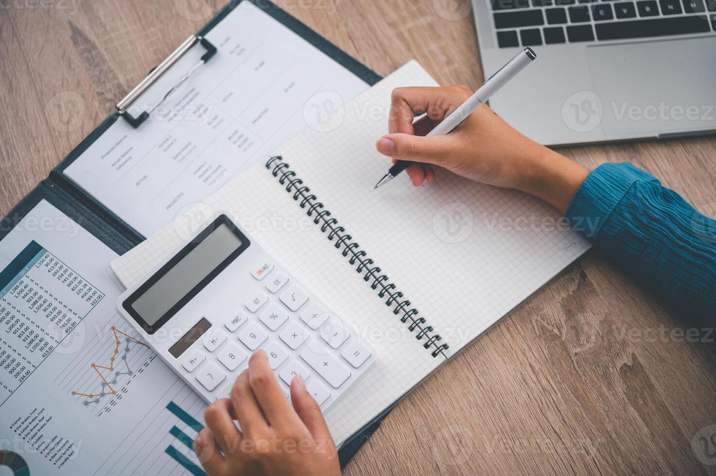 close up The business person is sitting on a calculator with a graph in the office of finance accounting concept photo