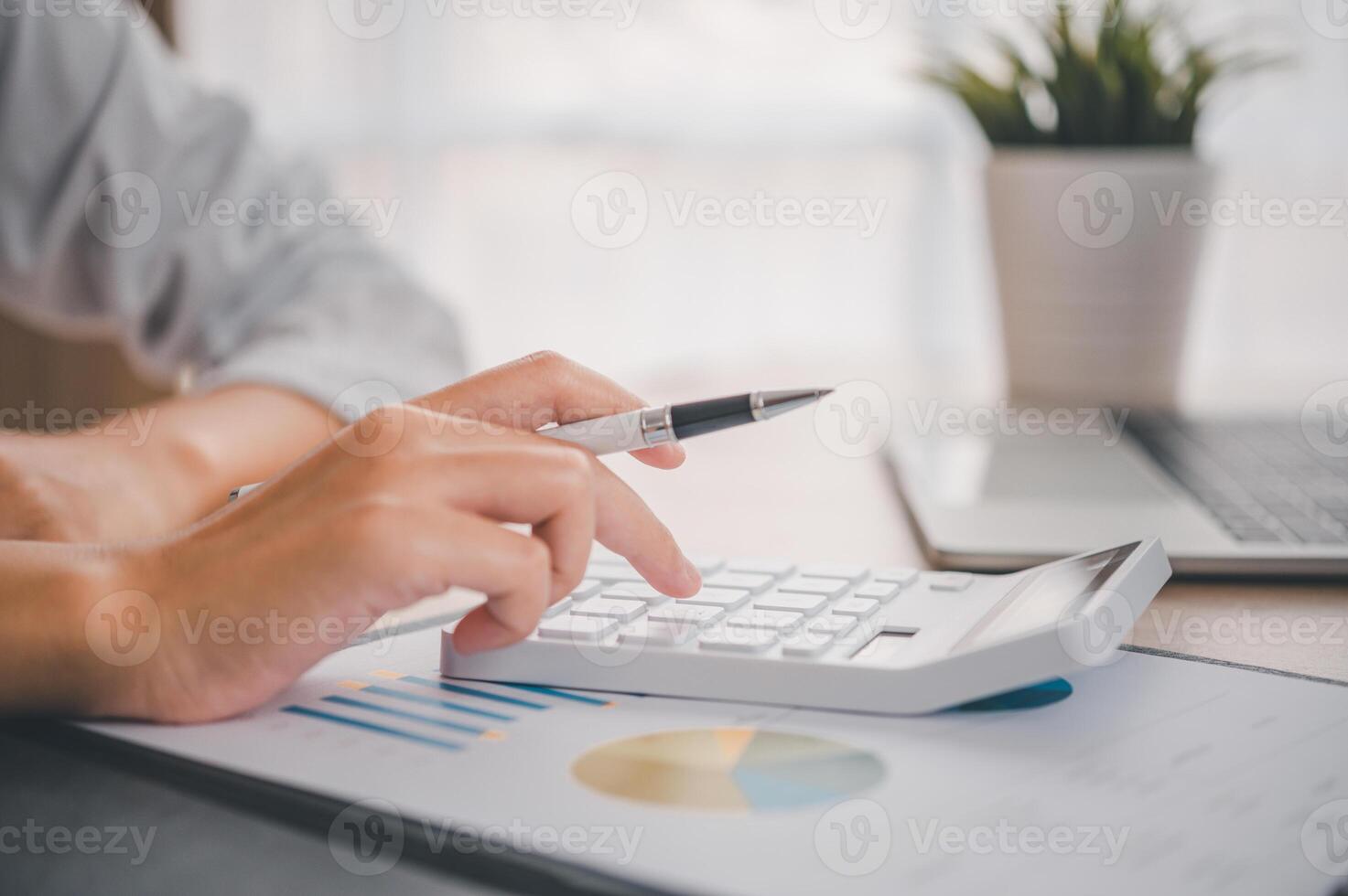 close up The business person is sitting on a calculator with a graph in the office of finance accounting concept photo