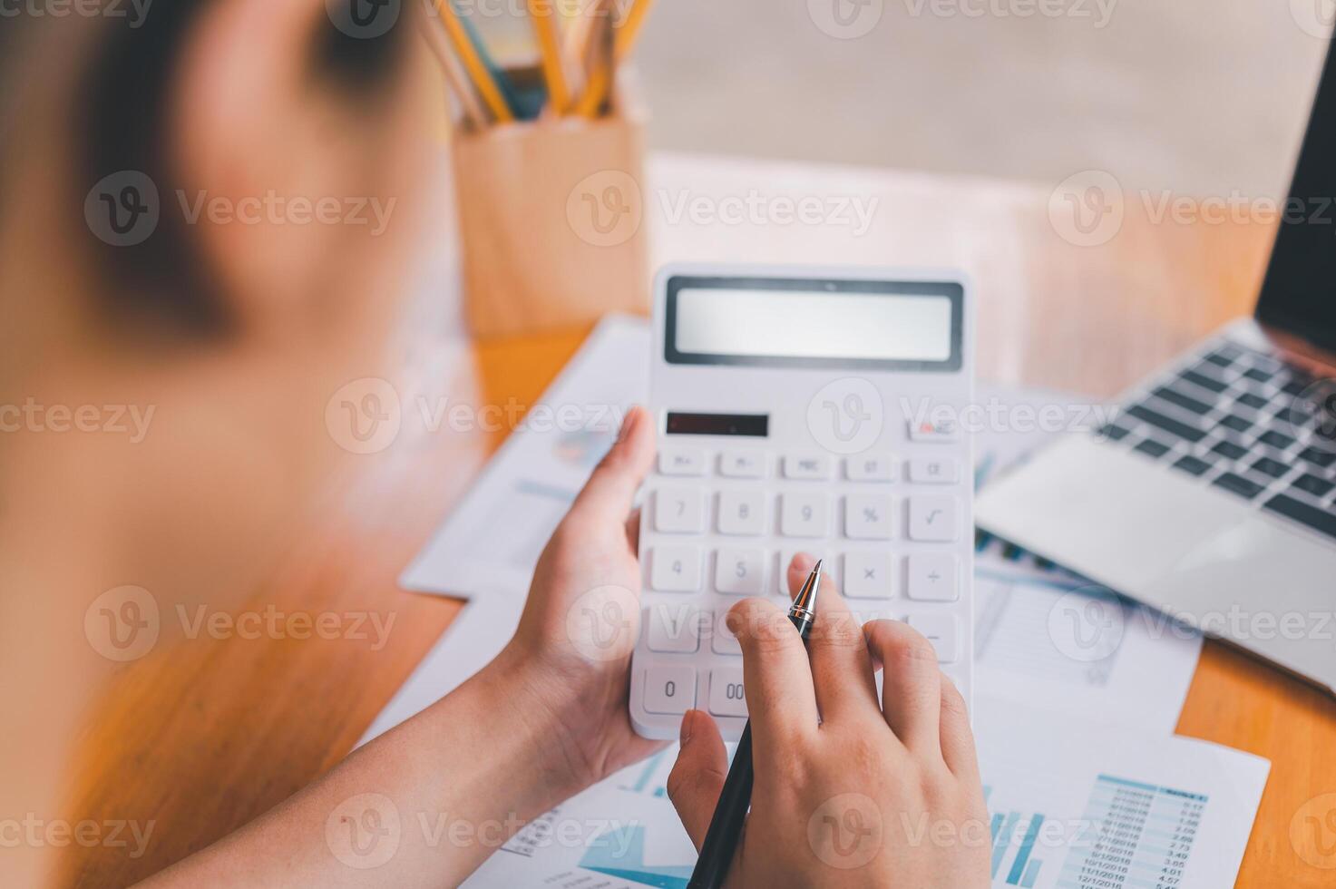 business person sitting at a desk at an office By using the calculator to work. Business Concept Analysis and Planning photo