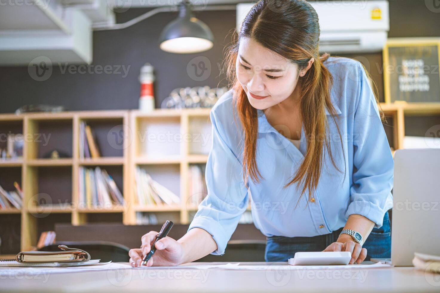 Business asian woman sitting at a desk at an office By using the calculator to work. Business Concept Analysis and Planning photo