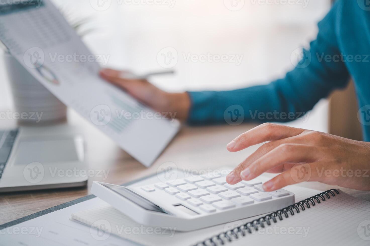 close up The business person is sitting on a calculator with a graph in the office of finance accounting concept photo