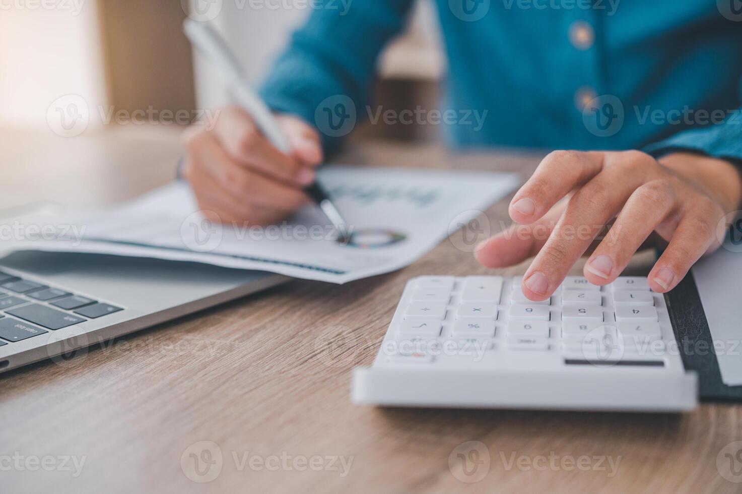 close up The business person is sitting on a calculator with a graph in the office of finance accounting concept photo