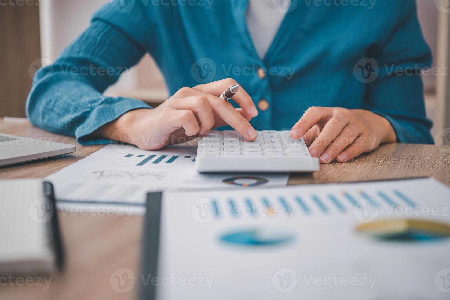 close up The business person is sitting on a calculator with a graph in the office of finance accounting concept photo