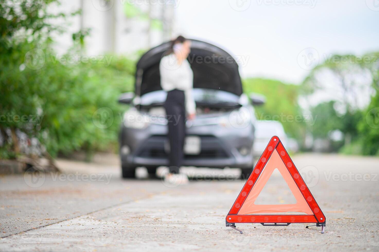 red emergency triangle on the road indicates that there is an accident or car breakdown on the road ahead. photo
