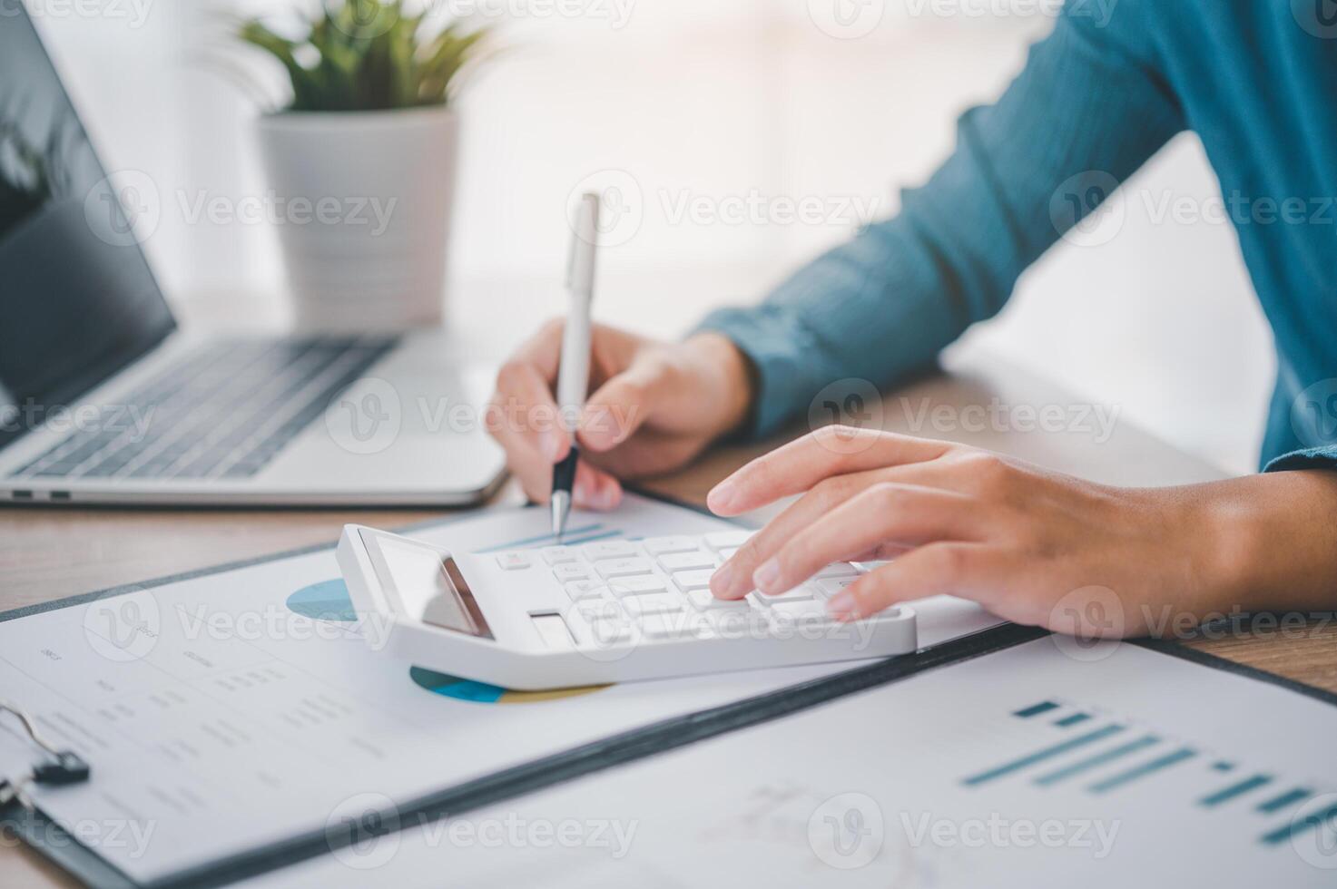 close up The business person is sitting on a calculator with a graph in the office of finance accounting concept photo