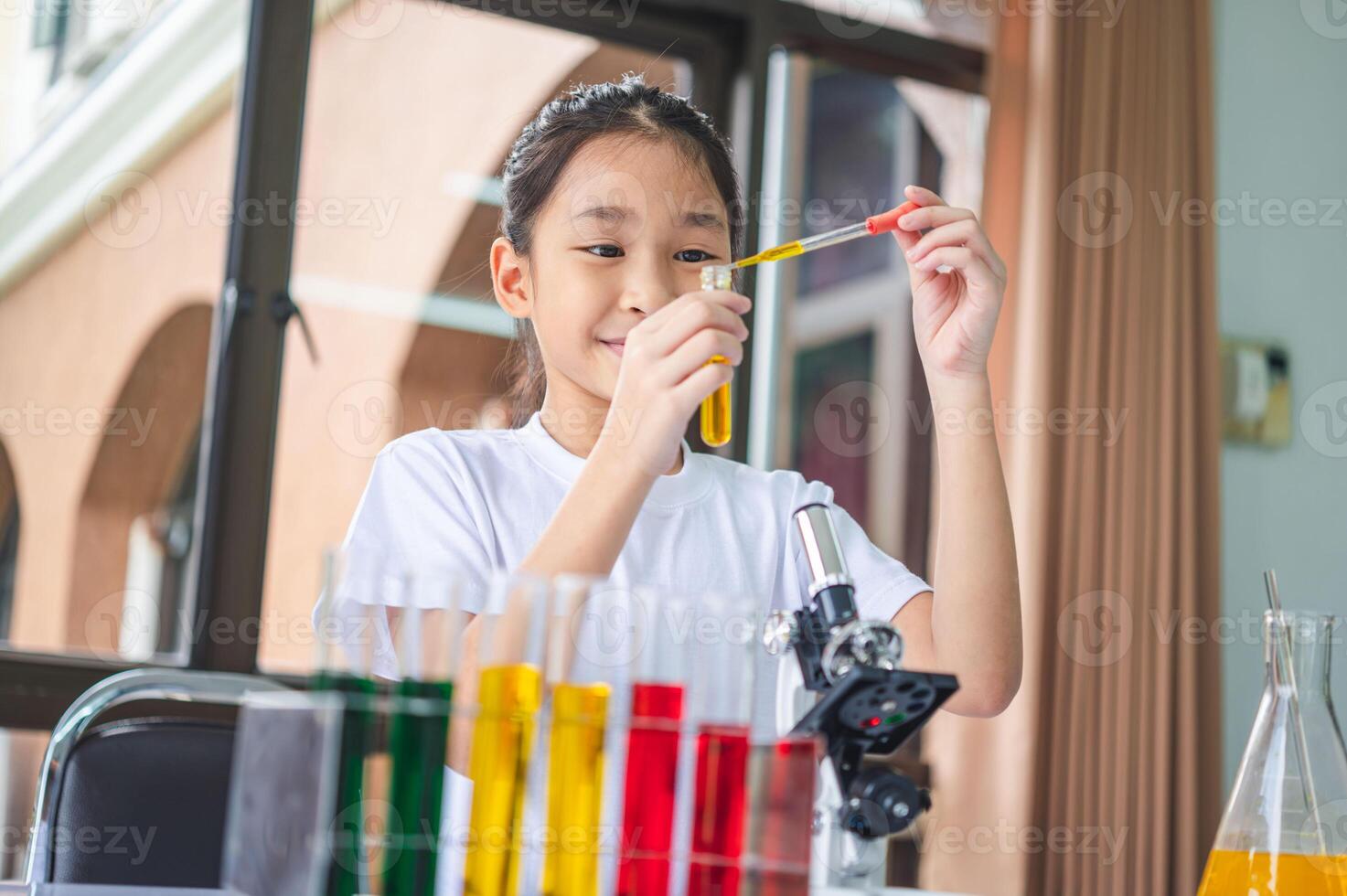 little scientist looking through a microscope and test tubes filled with chemicals for learning about science and experiments. photo