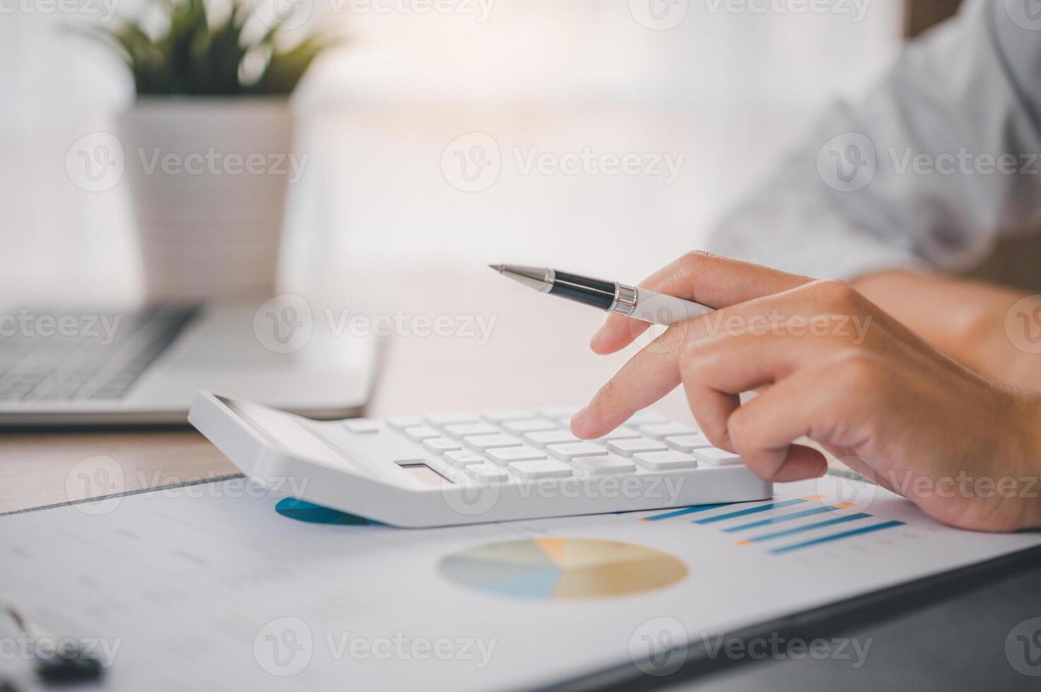 close up The business person is sitting on a calculator with a graph in the office of finance accounting concept photo