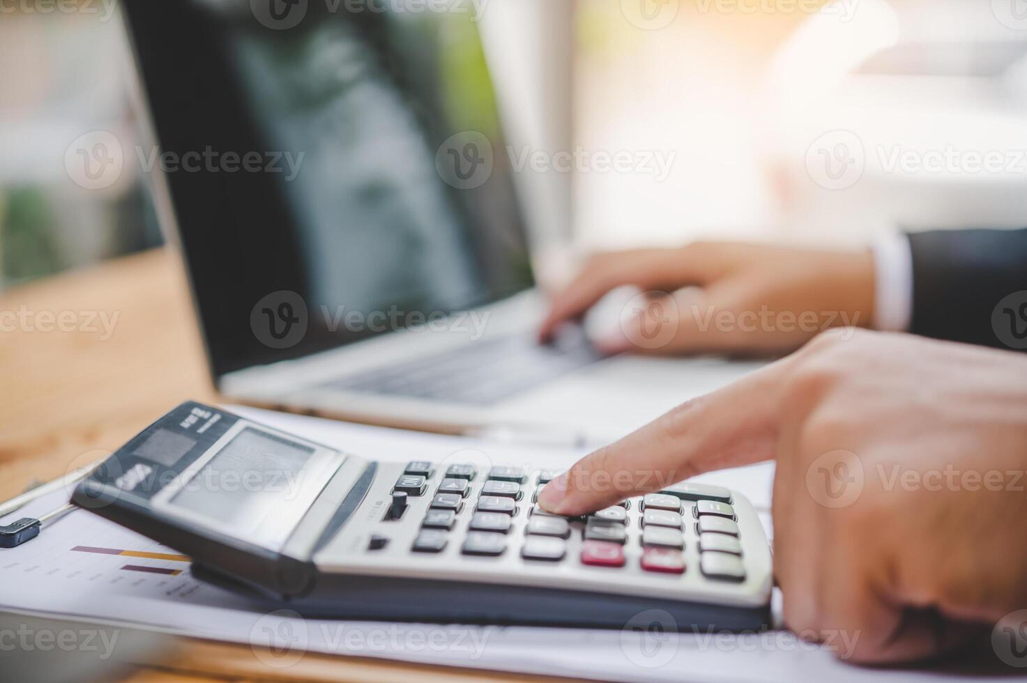 business person sitting at a desk at an office By using the calculator to work. Business Concept Analysis and Planning photo