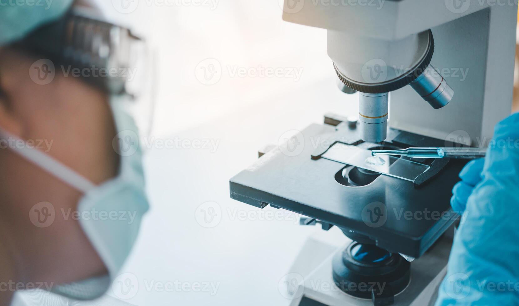 Female researchers are experimenting with pipette dropping a sample into a test tube in an experiment research in laboratory.. photo