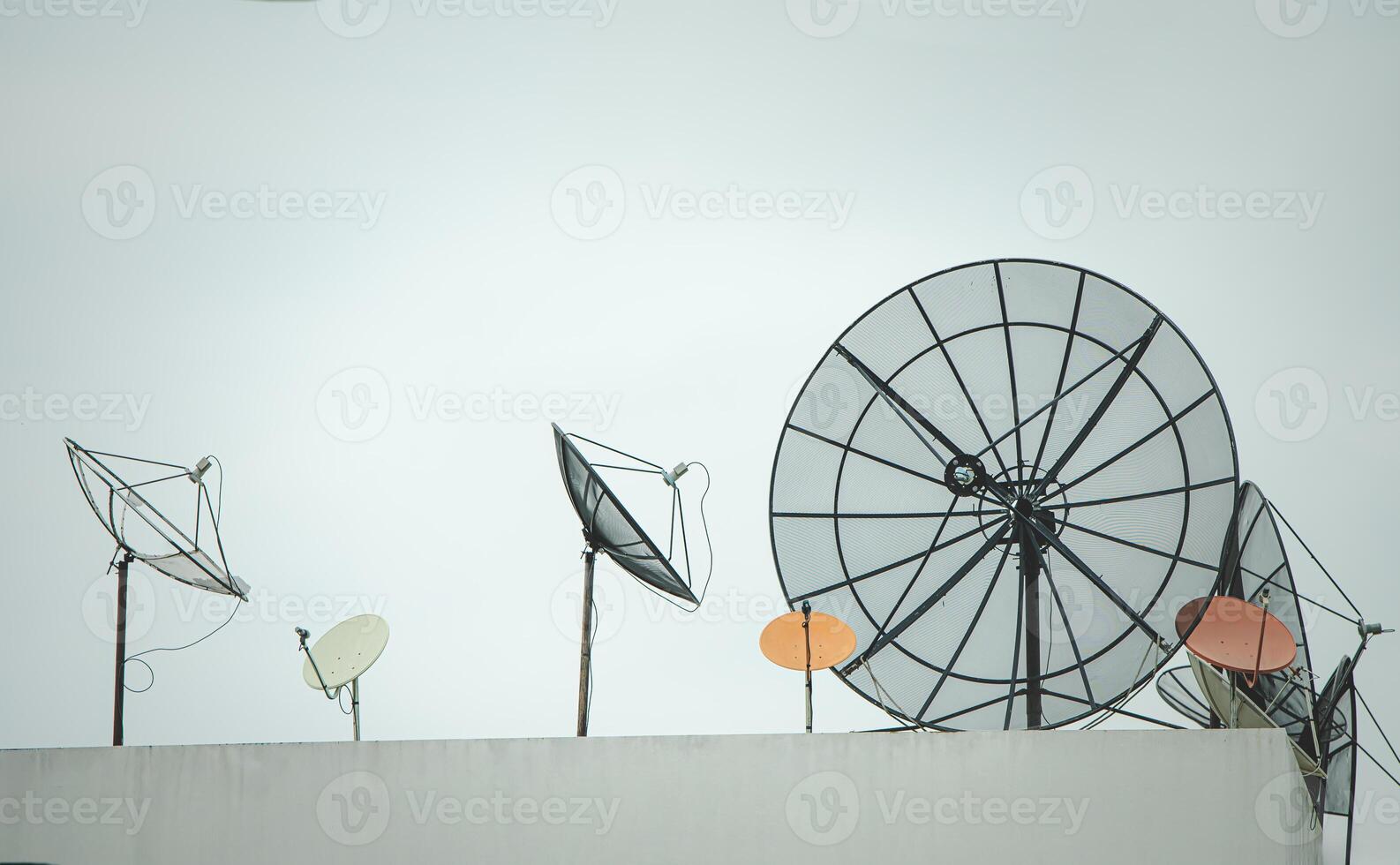 Many old communication satellite dishes expired and left on rooftops. photo