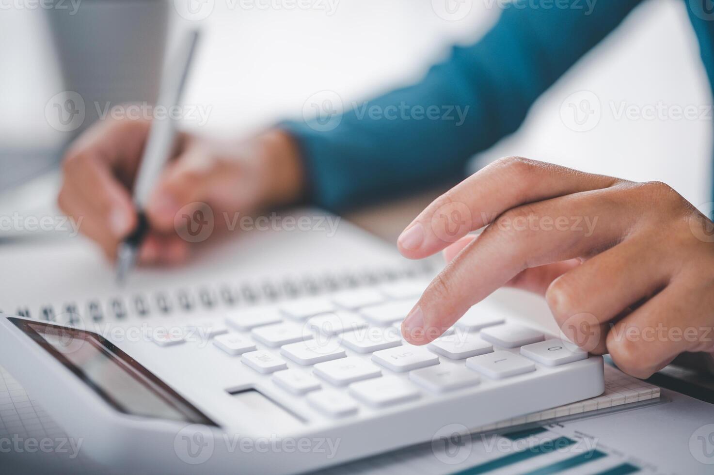 close up The business person is sitting on a calculator with a graph in the office of finance accounting concept photo