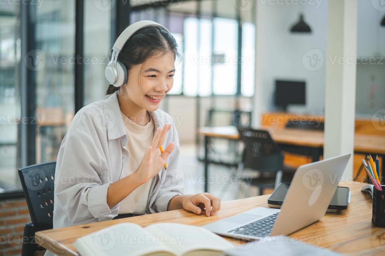 Teenage Asian students wearing a headphone are communicating through conferencing for online learning. In a conference call via apps. photo