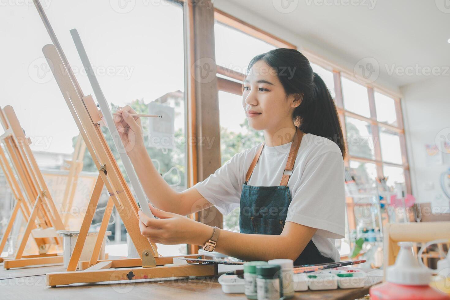 Art student drawing with watercolor painting on canvas doing some art projects on studio workshop photo