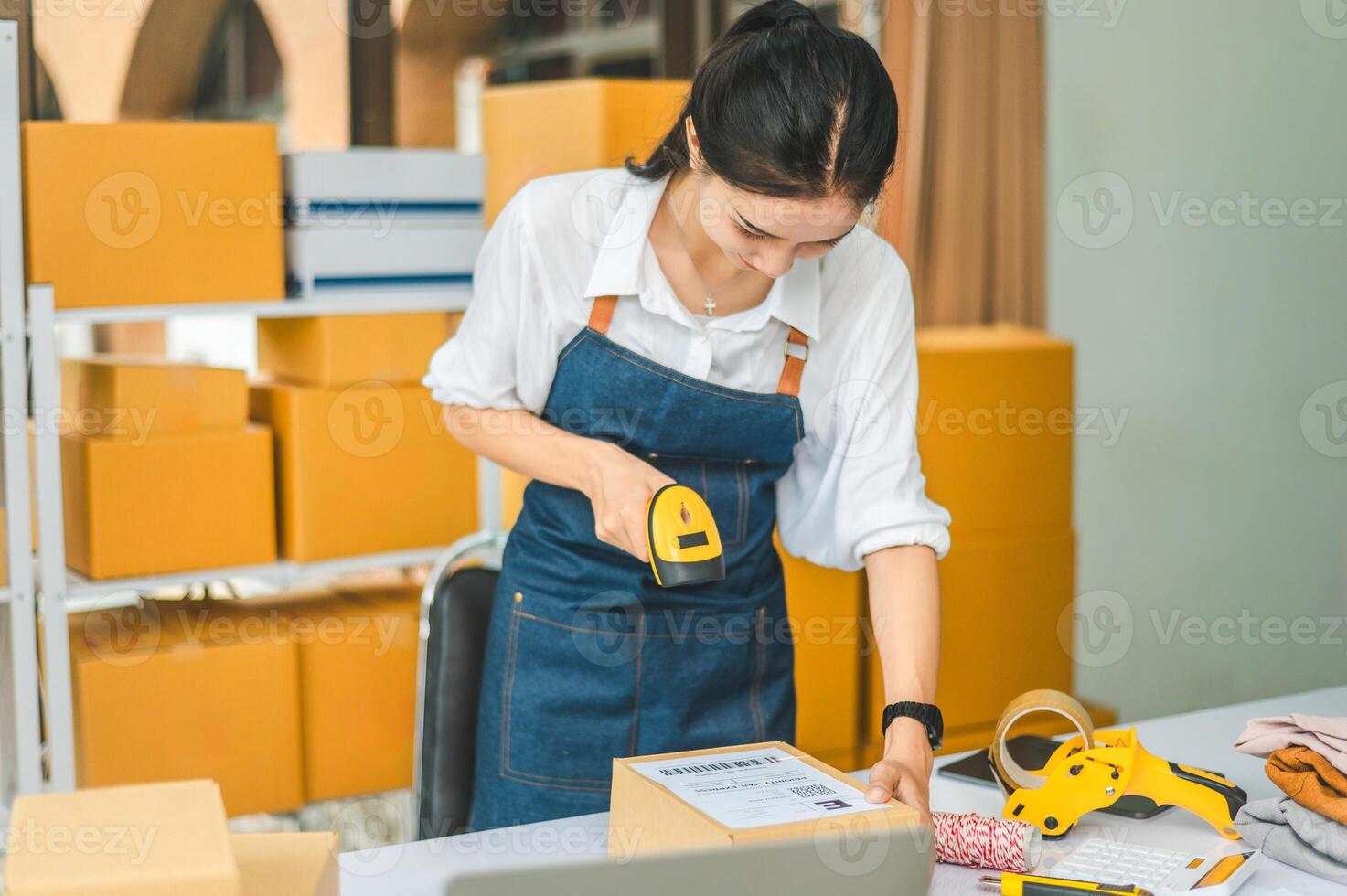 online small business owner scans a barcode-labeled parcel with a barcode scanner to verify a customer's order before it is delivered to the customer. photo