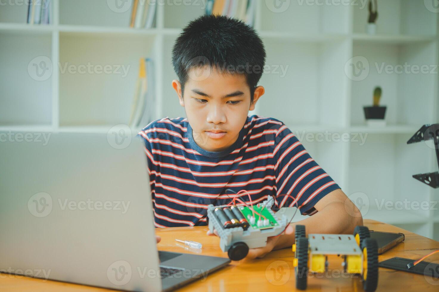 Asian boy learning and studying the work of technology robots.homeschool and science for tech project. playing childhood kids hobby leisure lifestyle people toys robotics technology. photo