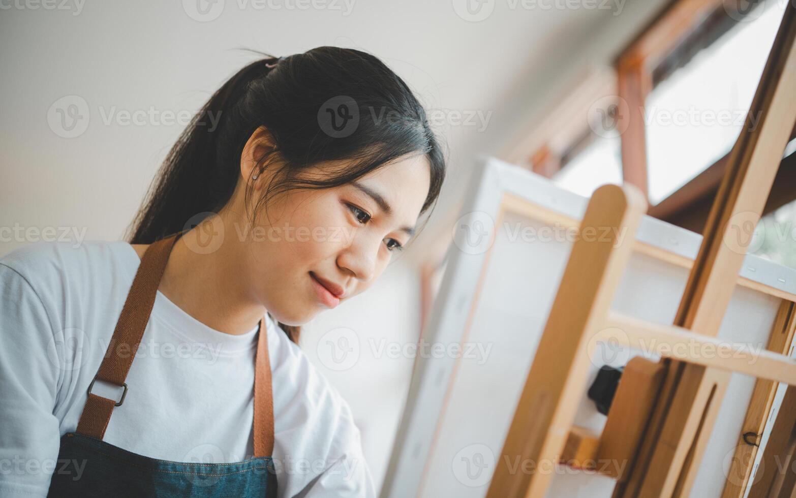 Art student drawing with watercolor painting on canvas doing some art projects on studio workshop photo