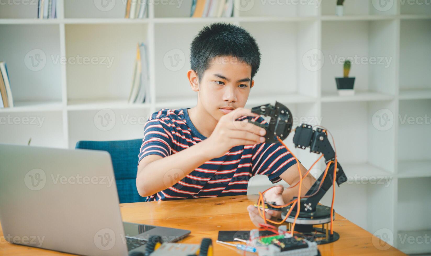 Asian boy learning and studying the work of technology robots.homeschool and science for tech project. playing childhood kids hobby leisure lifestyle people toys robotics technology. photo