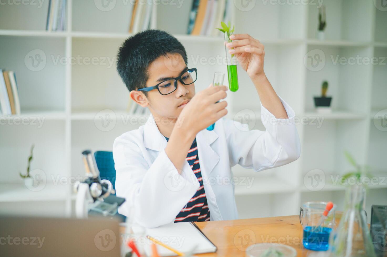 Asian male science students looking through a microscope and tests of plants in the classroom. Learning about scientific experiments on plant species. photo