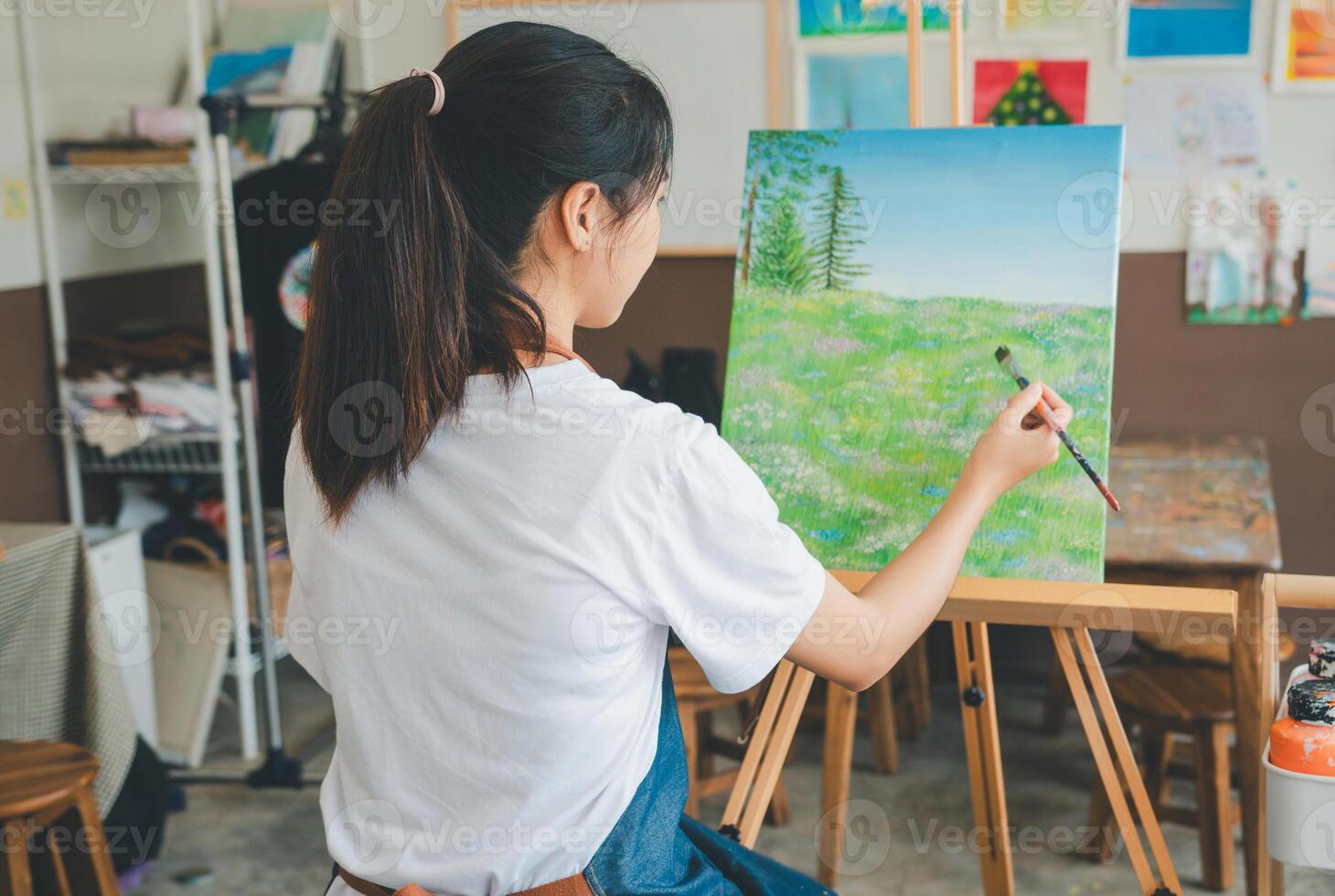Art student drawing with watercolor painting on canvas doing some art projects on studio workshop photo