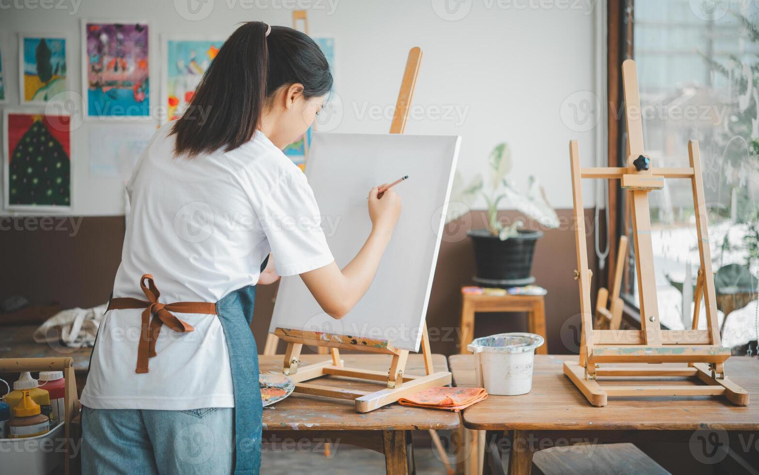 Art student drawing with watercolor painting on canvas doing some art projects on studio workshop photo