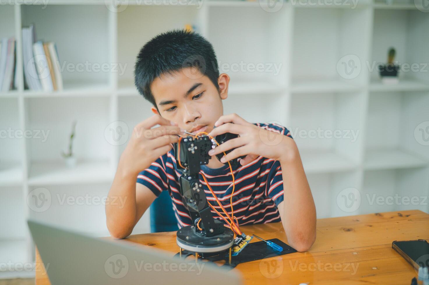 Asian boy learning and studying the work of technology robots.homeschool and science for tech project. playing childhood kids hobby leisure lifestyle people toys robotics technology. photo