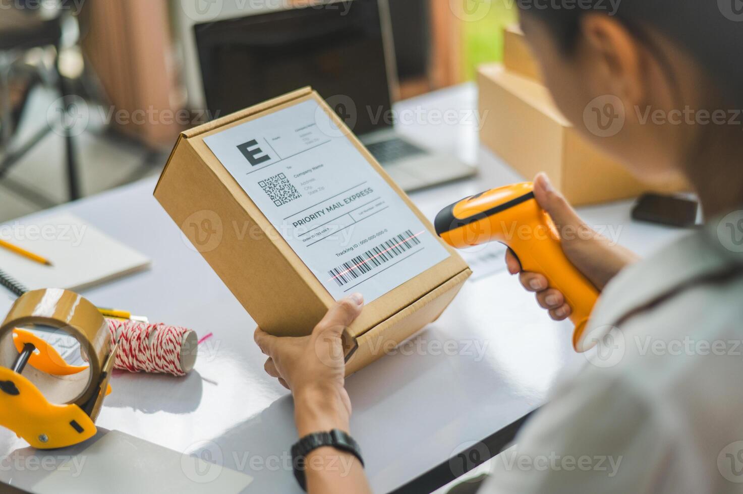 online small business owner scans a barcode-labeled parcel with a barcode scanner to verify a customer's order before it is delivered to the customer. photo