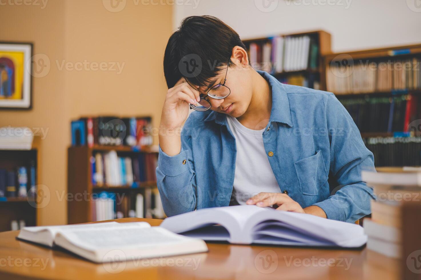 Students feel tired and stressed after working on their laptops and looking for books to study, make reports, find useful information in the university room. photo