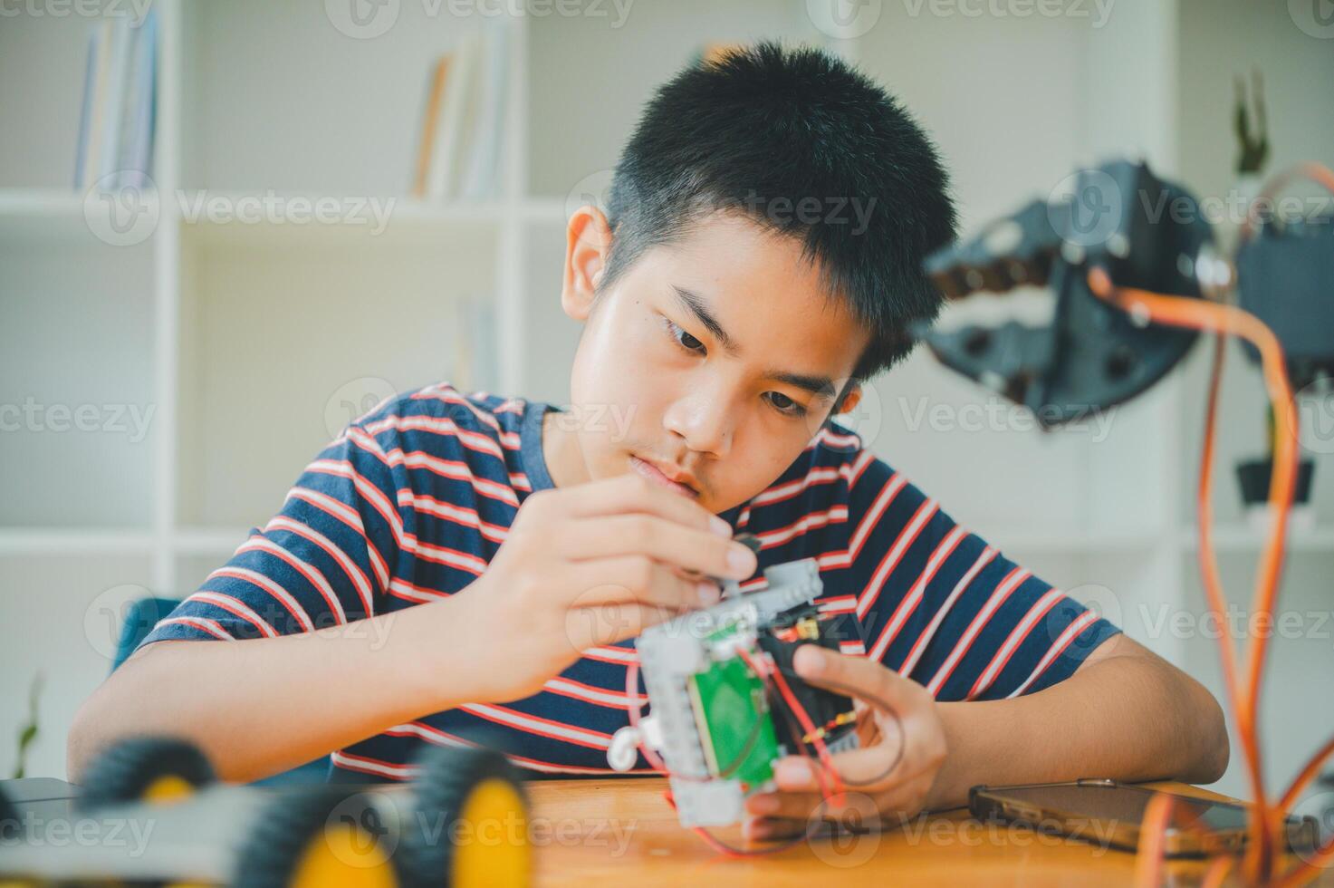 Asian boy learning and studying the work of technology robots.homeschool and science for tech project. playing childhood kids hobby leisure lifestyle people toys robotics technology. photo