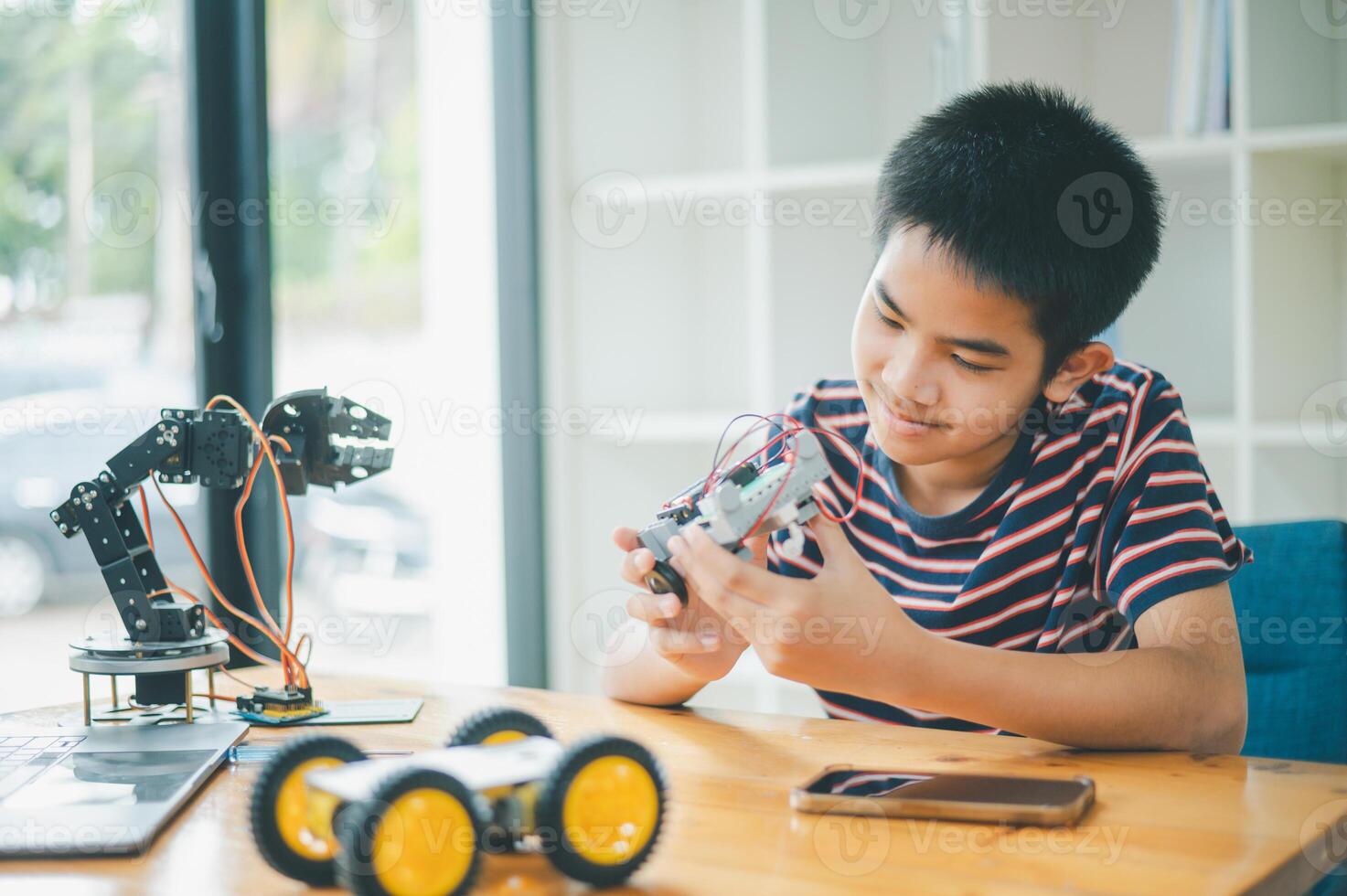 Asian boy learning and studying the work of technology robots.homeschool and science for tech project. playing childhood kids hobby leisure lifestyle people toys robotics technology. photo