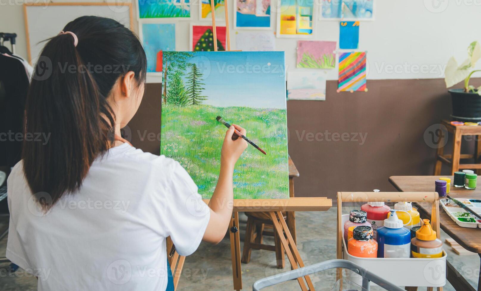 Art student drawing with watercolor painting on canvas doing some art projects on studio workshop photo