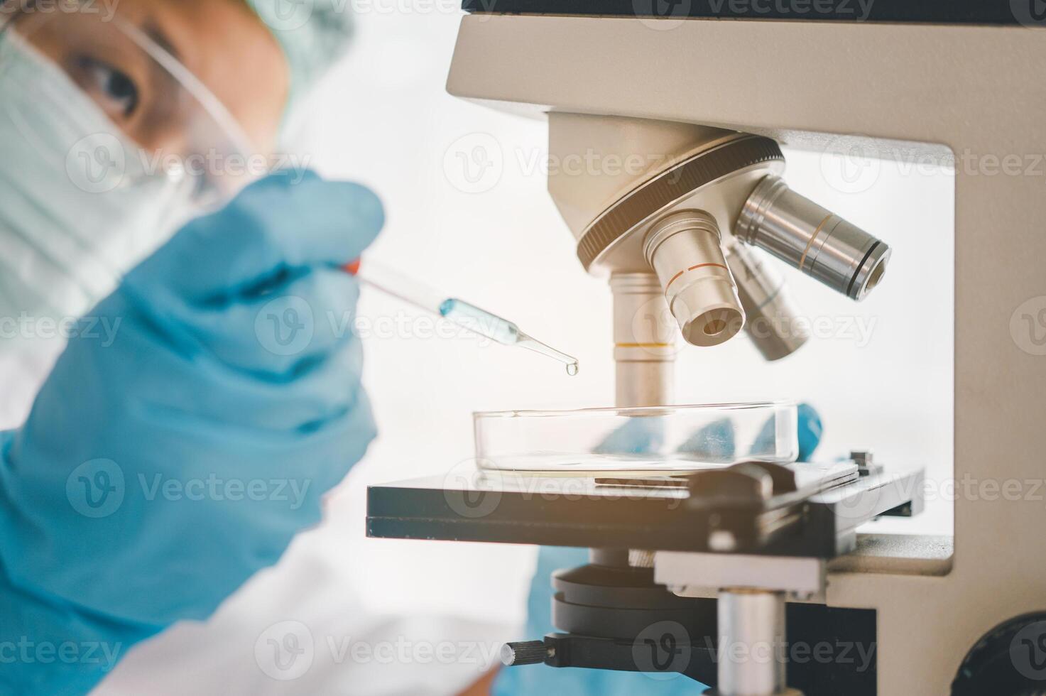 Female researchers are experimenting with pipette dropping a sample into a test tube in an experiment research in laboratory.. photo