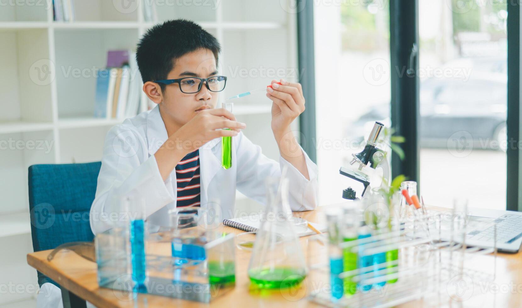 Asian male science students looking through a microscope and tests of plants in the classroom. Learning about scientific experiments on plant species. photo