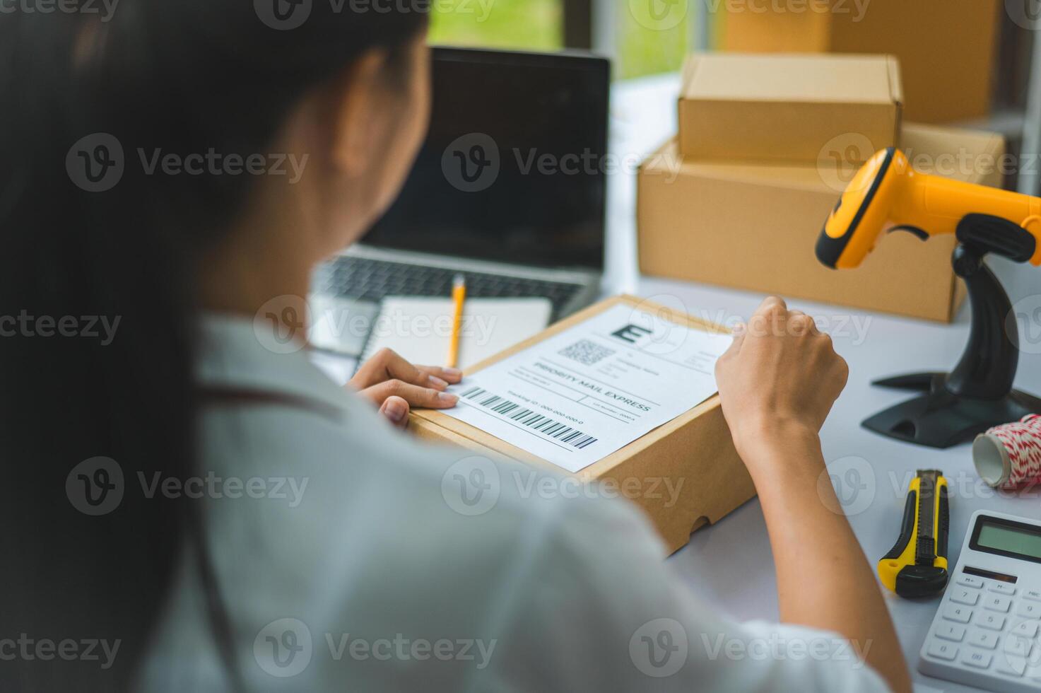 startup young female small business owners attaching shipping labels to cardboard boxes or parcels for delivery of customer orders-concept shopping online photo
