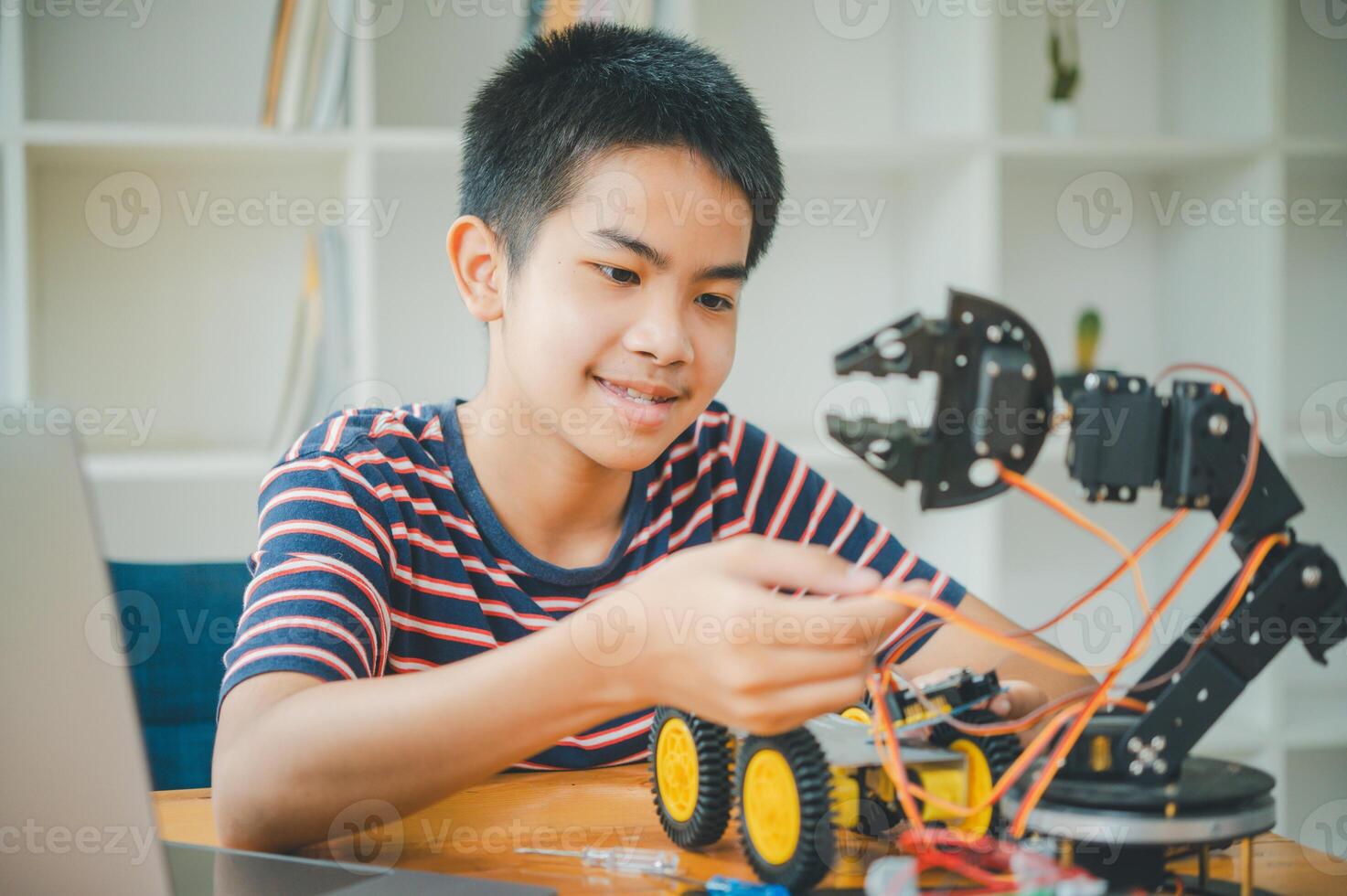 Asian boy learning and studying the work of technology robots.homeschool and science for tech project. playing childhood kids hobby leisure lifestyle people toys robotics technology. photo