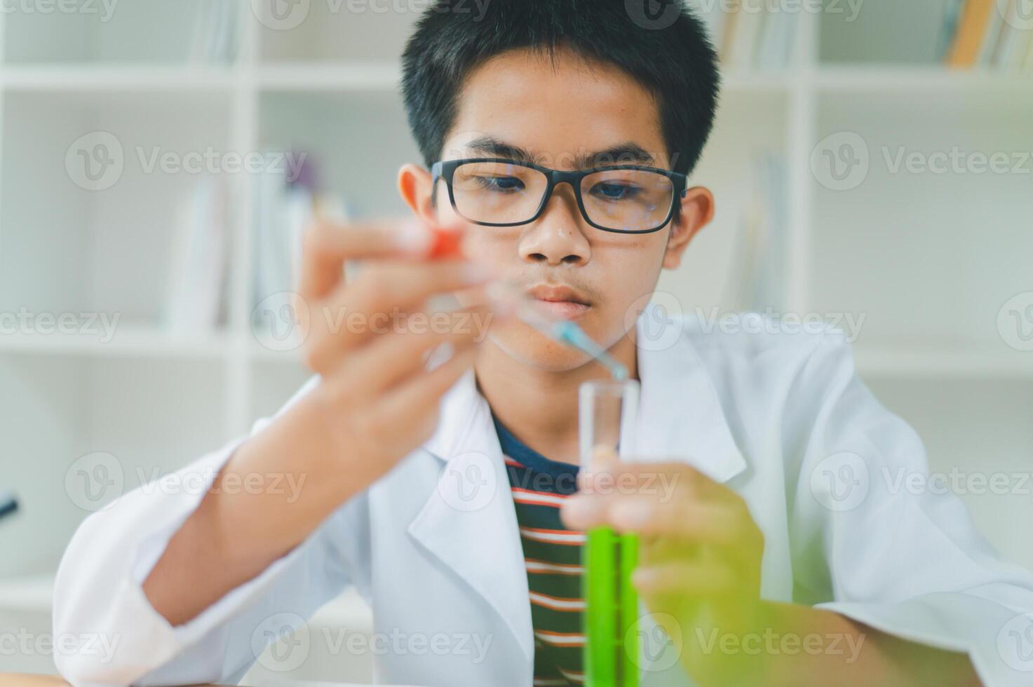 Asian male science students looking through a microscope and tests of plants in the classroom. Learning about scientific experiments on plant species. photo